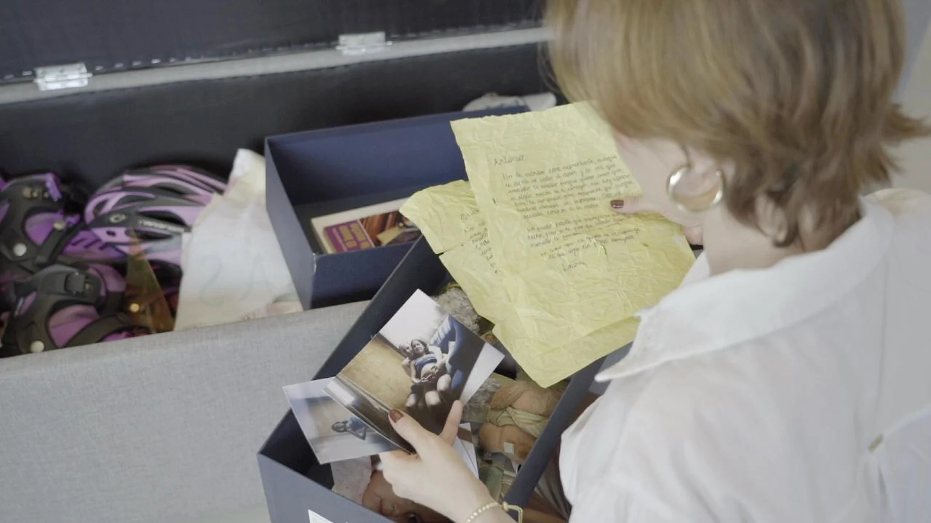 Actriz leyendo cartas y fotografías en una escena de Raíces y Alas, producción audiovisual de Melissa Osorio