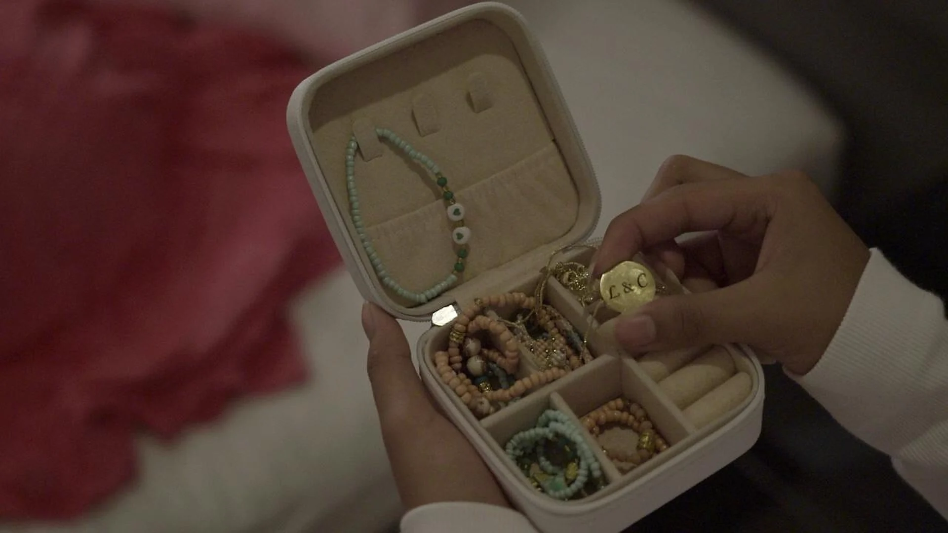 Manos sosteniendo un joyero con pulseras en una escena de Raíces y Alas